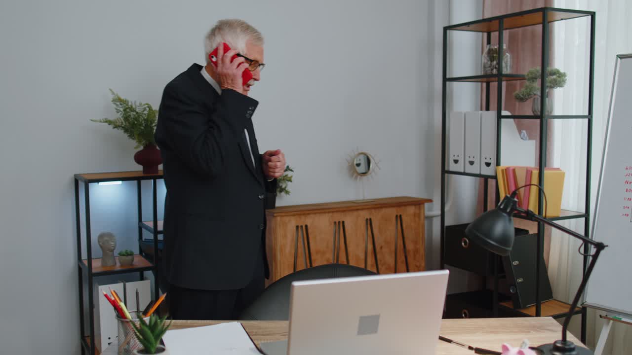 화가 난 상급 사업가 사무실에서 전화를 하고 있습니다. 직장 직원이 화를 내고 있습니다.