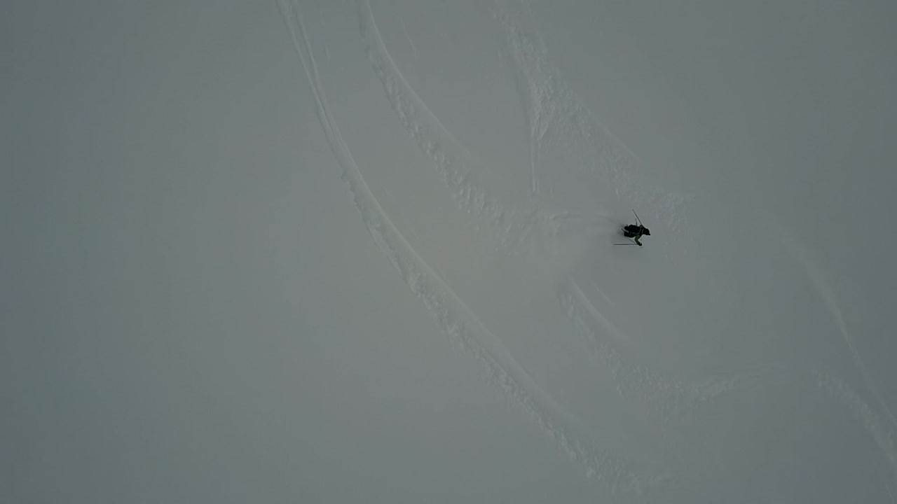 파우더 슬로프를 내려가는 스키어의 드론 영상