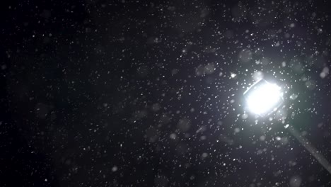 particles on a black background against a lamppost