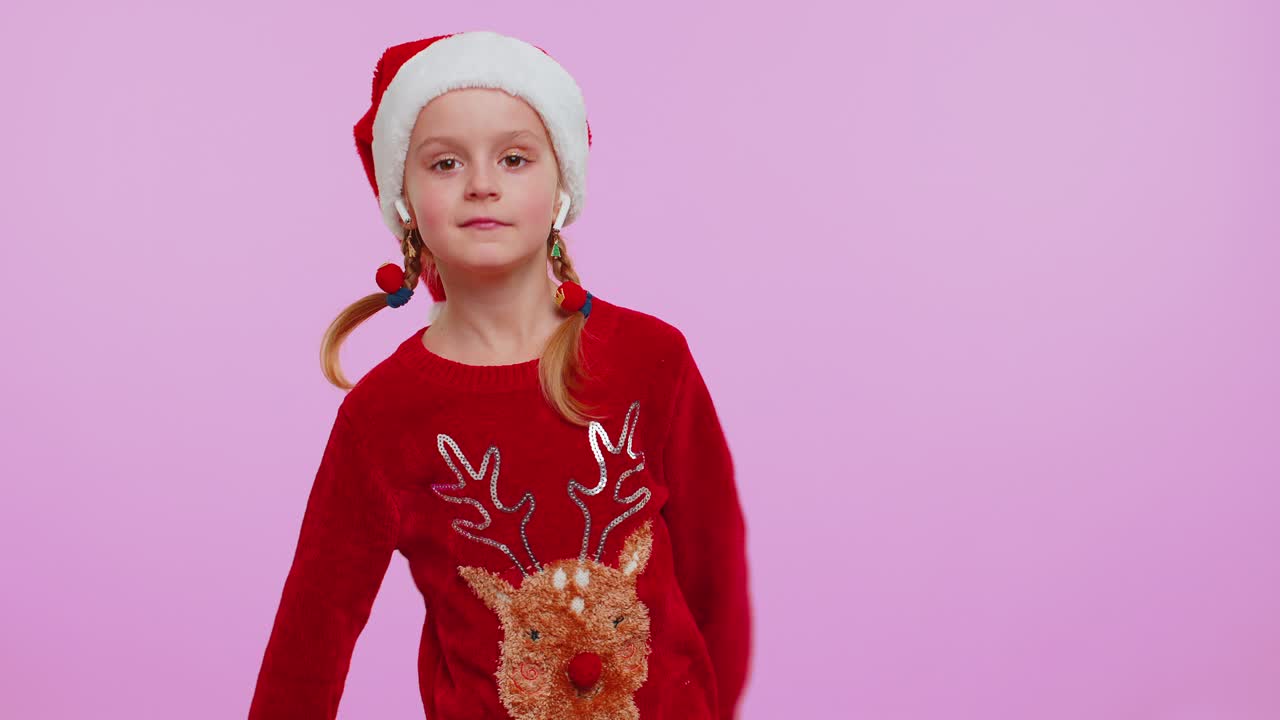 크리스마스 스웨터를 입은 소녀는 이어폰을 통해 음악을 듣고, 디스코 춤을 추며 즐거운 시간을 보내고 있습니다.