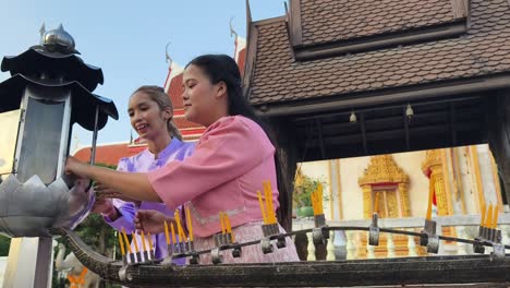 women praying at a thai temple