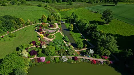 approaching drone movement to the beautiful modernity manicured upper brittany botanical park with amazing garden layout and pond, le chatellier, france.