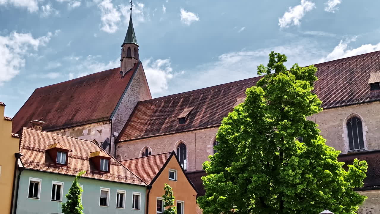 Tidigare minoritkyrkan Sankt Salvator i Regensburg med gotiska fönster och stenmurar.