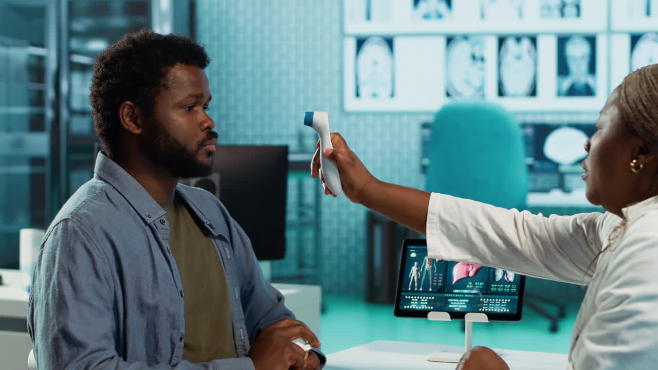 Medical specialist consulting a young patient with thermometer in cabinet