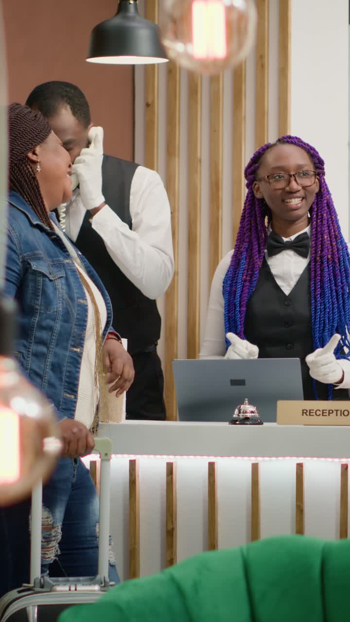 Vertical video Receptionist welcoming guests at hotel