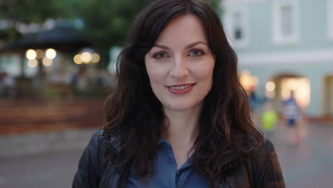 close-up-portrait-of-happy-elegant-woman-smiling-at-camera-enjoying-peaceful-urban-evening