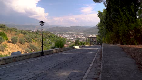 Road-leading-down-towards-beautiful-city-in-Berat,-Albania
