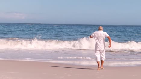 Älterer-Mann-Rennt-Und-Springt-Am-Strand