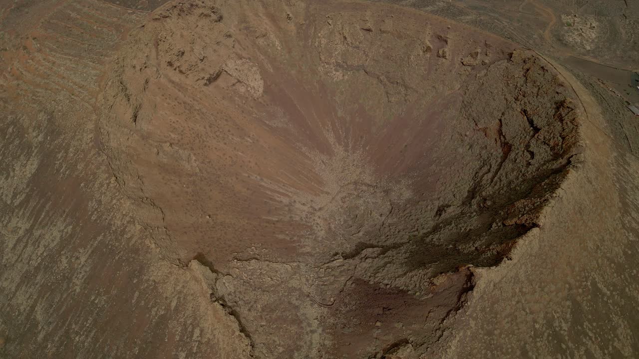 Volcano crater. Aerial view dolly out of volcano. Interior of a volcanic crater and lava outlet area. Canary Islands. Spain.
