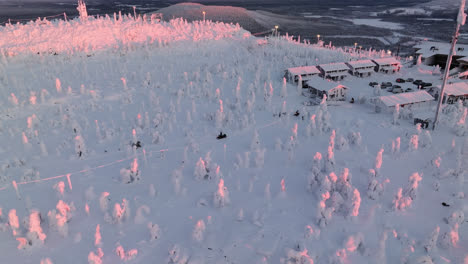 Vista-Aérea-Alrededor-De-Una-Moto-De-Nieve-Encima-De-La-Caída-De-Iso-syote,-Amanecer-En-Finlandia