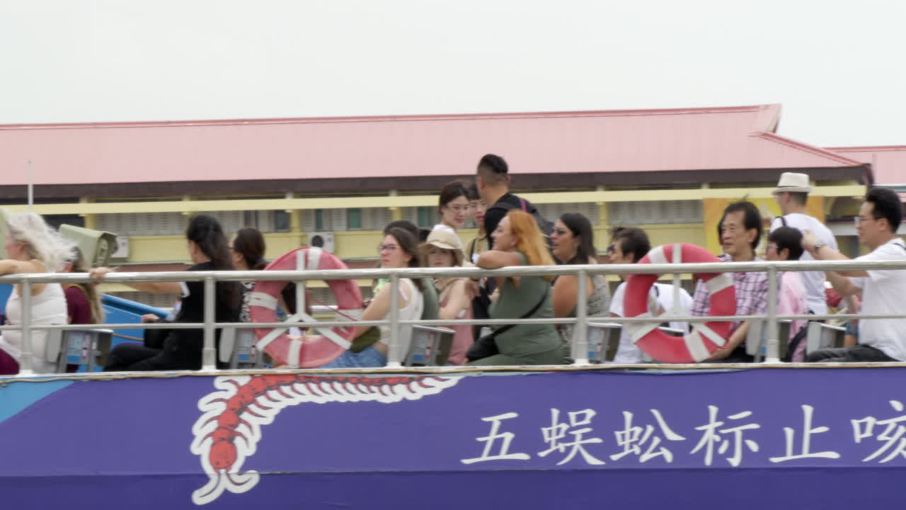 Ferry cruising along the waterways of Chao Phraya River, carrying a group of local and foreign tourists on a tour in Bangkok, Thailand.