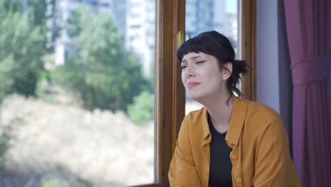 depressed young woman. the young woman is watching out the window.