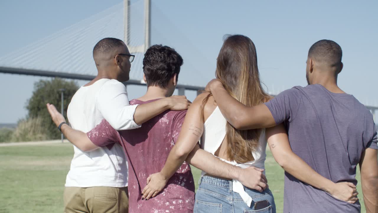 미소 짓는 친구들이  ⁇ 안고 초원에서  ⁇ 고 있는 뒤의 모습.