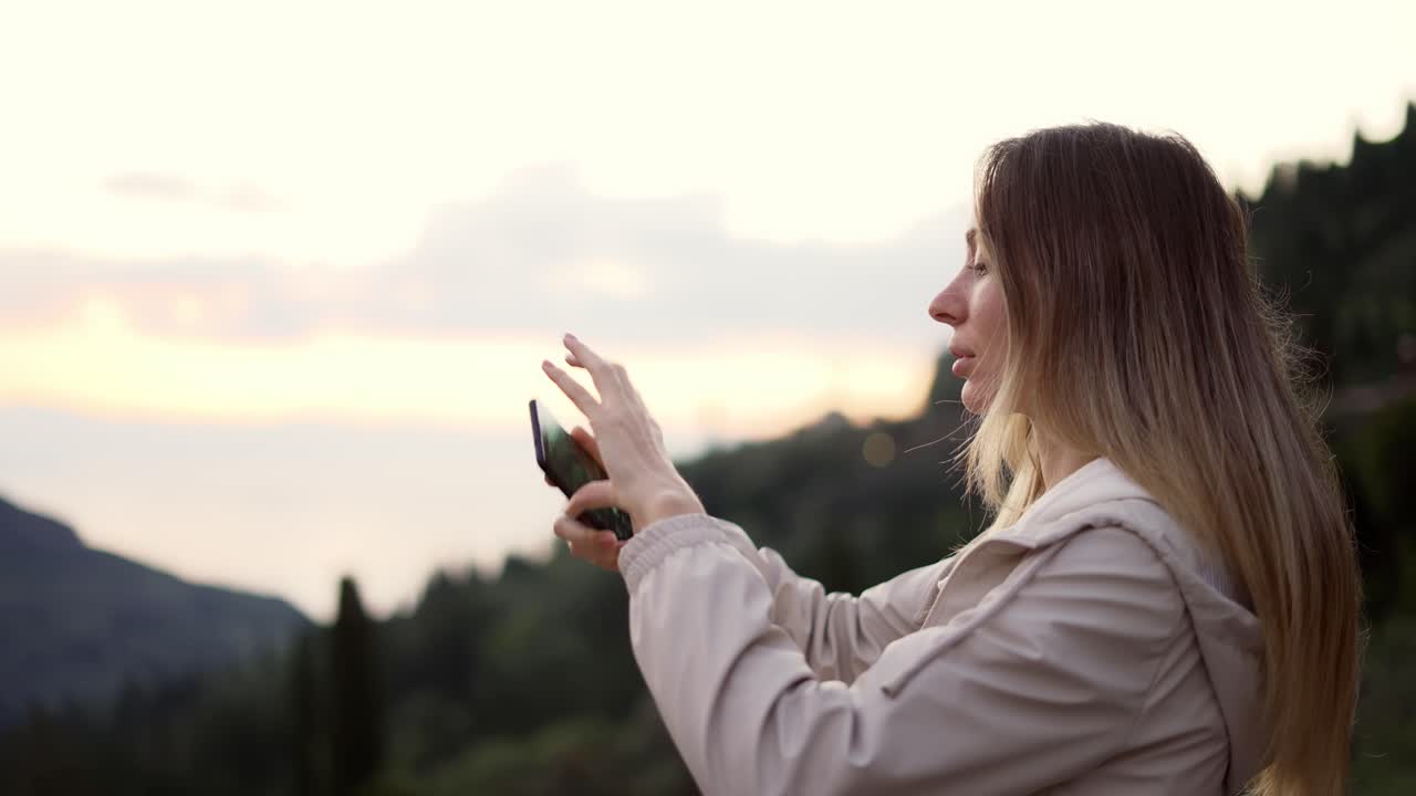 mujer de pelo largo toma una foto con un teléfono inteligente en sus manos