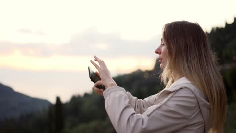 long haired woman takes a photo with a smartphone in her hands