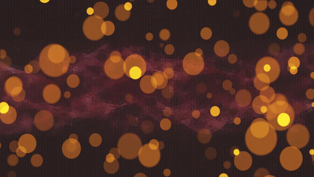 Animation of glowing orange and yellow bokeh light spots multiplying on dark background