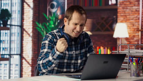 hombre disfrutando del tiempo libre en casa, enviando mensajes de texto a amigos en la computadora portátil