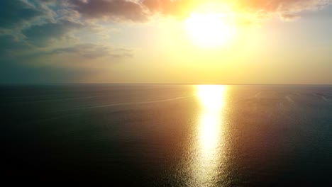 el vuelo sobre el mar en un fondo de sol brillante. tiro de cuadrocóptero