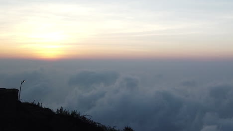 The-sun-rising-above-the-clouds-early-in-the-morning-high-in-the-mountains-above-Kodaikanal,-Tamil-Nadu,-India