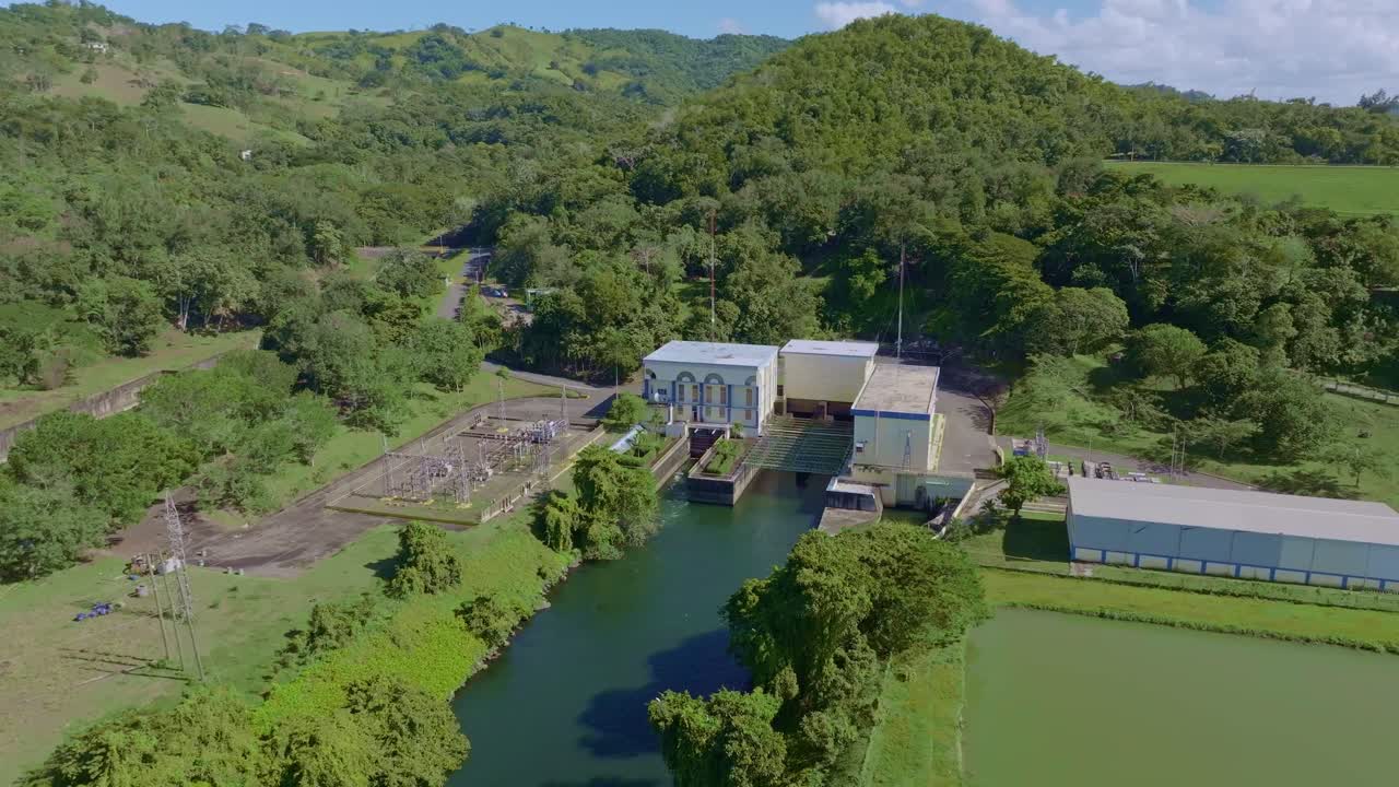 Hatillo Dam, hydroelectric power station, power transmission infrastructure, lush greenery, ideal for renewable energy and industrial footage, Dominican Republic. Aerial drone