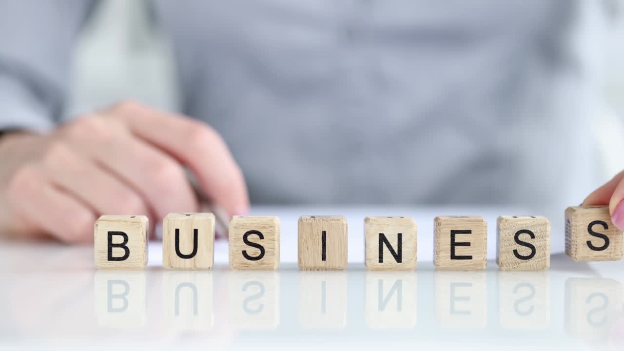 Person adds letters s to word business. closeup