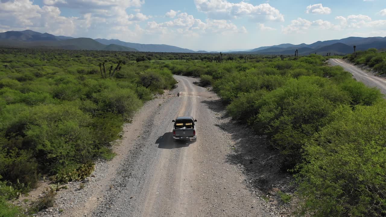 전형적인 멕시코 자연 경관을 통해 운전하는 차를 따라가는 드론