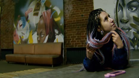 woman with dreadlocks in a graffiti-filled urban space