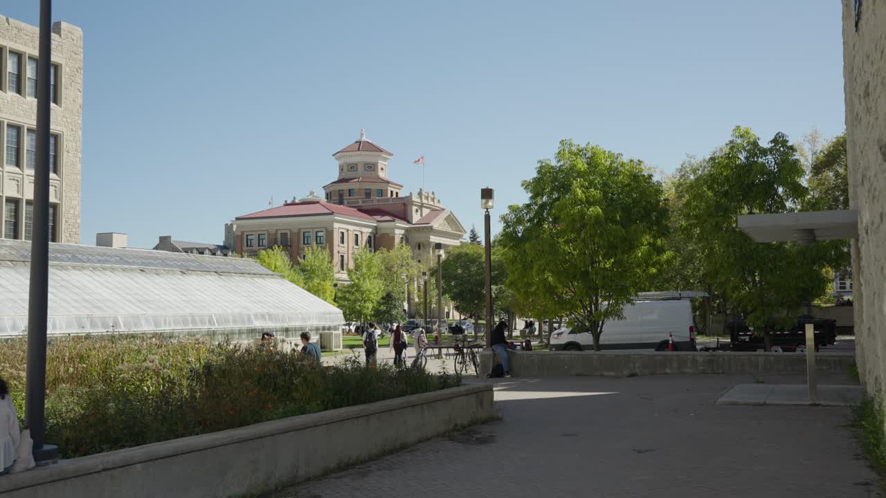 Static long shot captures University of Manitoba administration building with campus activity in Winnipeg