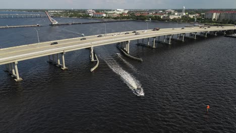boats passing beneath the green bridge in bradenton, florida, with cars traveling above. crane up