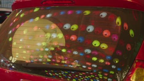 static shot of the bright lanterns hanging reflecting in a car window