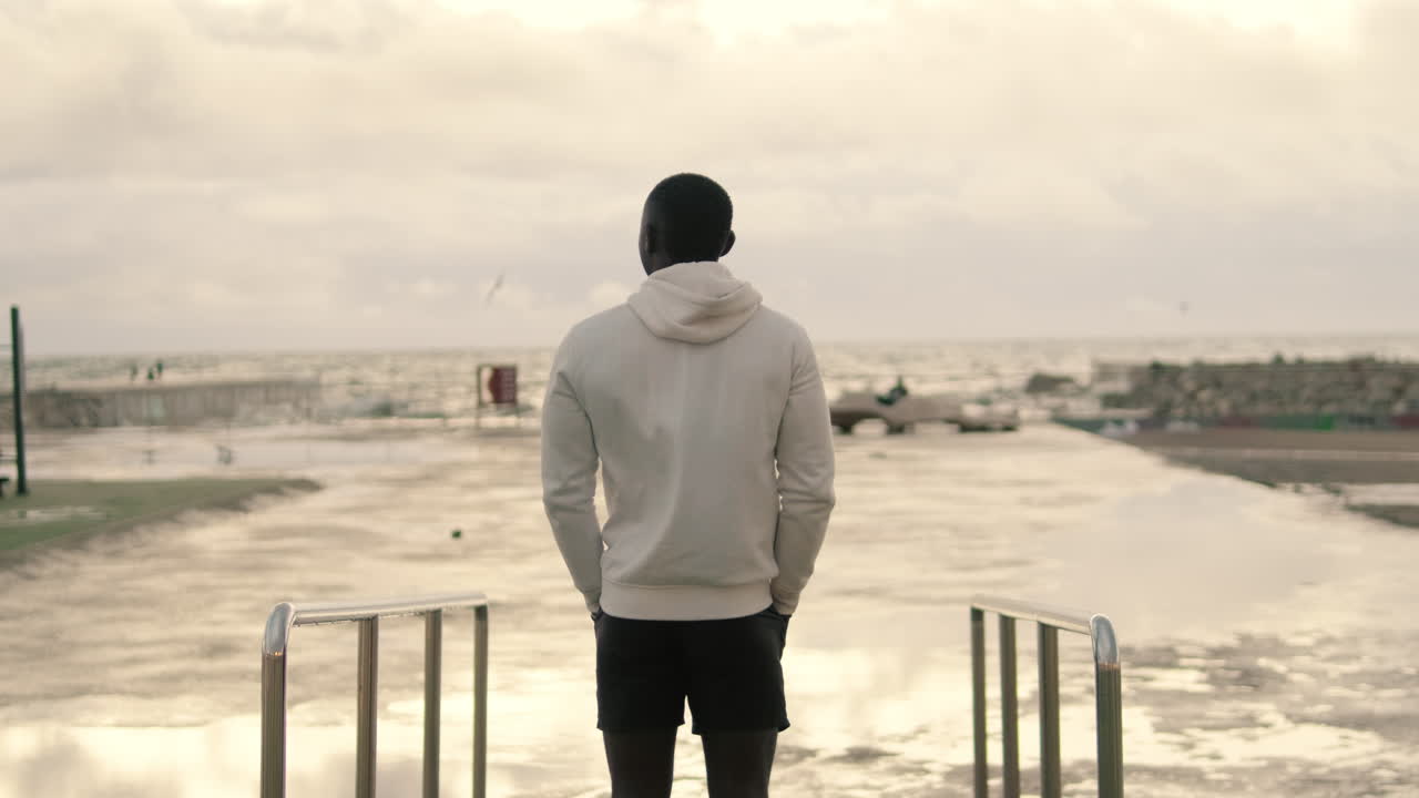 Ung mand, der står og kigger ud over havet
