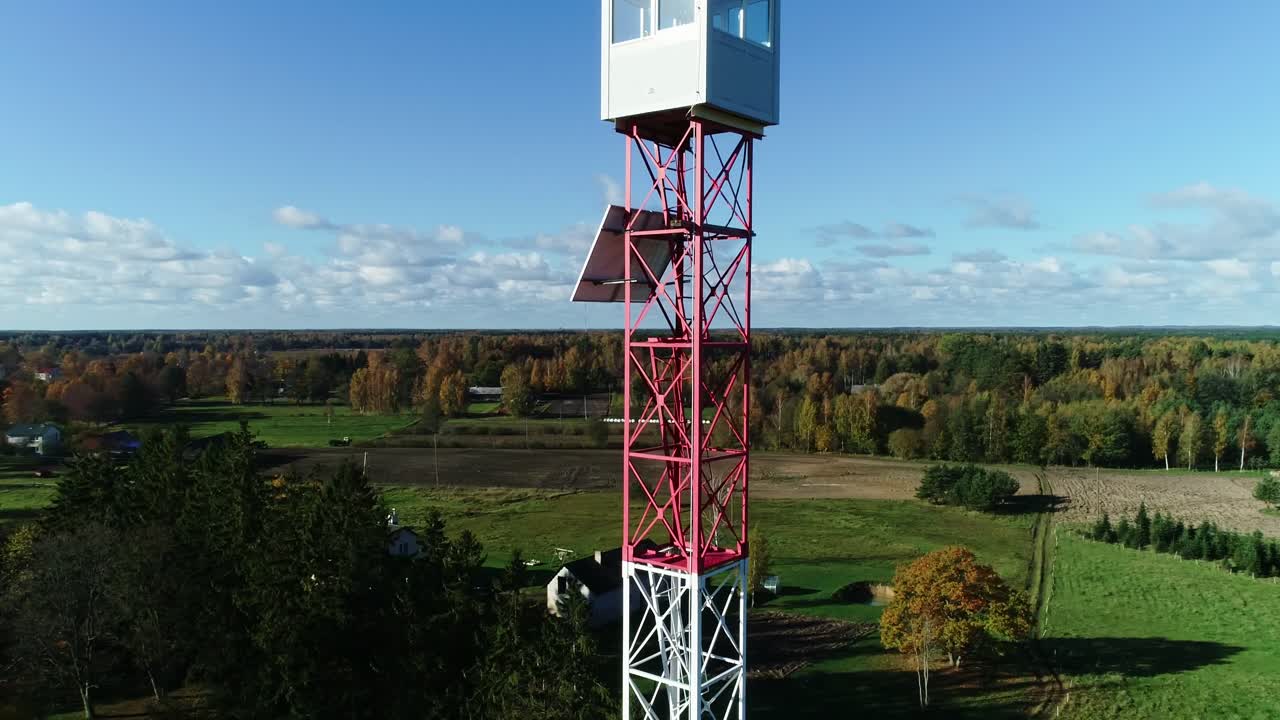 Drone cinematic orbit fire watch tower Rucava Latvia with solar powered panel