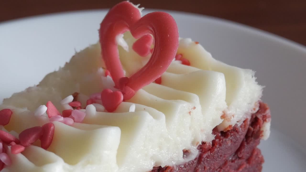 Red velvet brownie with creamy frosting, heart decorations, romantic Valentine's vibe