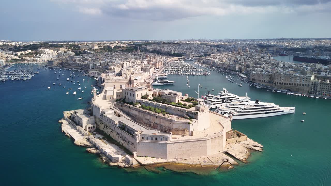 Aerial view of historic fort by the sea with yachts and cityscape