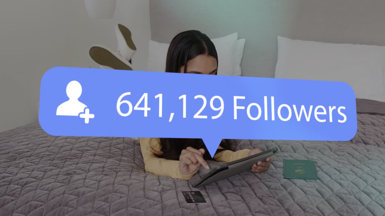 Woman on bed tapping tablet using card, causing social follower overlay rising, boosting reach