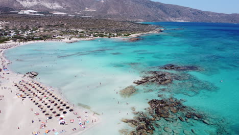 Impresionante-Antena-Sobre-La-Playa-Turística-De-Elafonissi-Y-El-Claro-Mediterráneo,-Creta