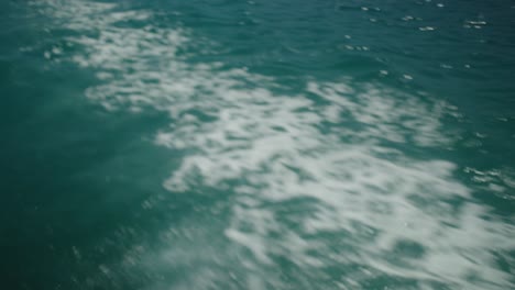 Mid-shot-of-ocean-waves-as-boat-cruises-across-it