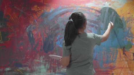 child painting abstract art on wall