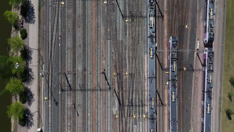 Top-Down-Aerial-View-of-Train-Entering-Helsinki-Central-Station,-Finland