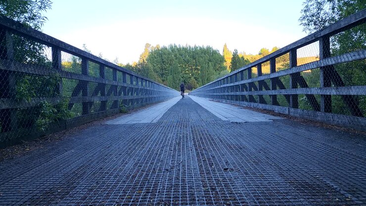 Traveller on bicycle riding over historic bridge