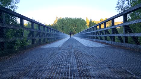 traveller on bicycle riding over historic bridge