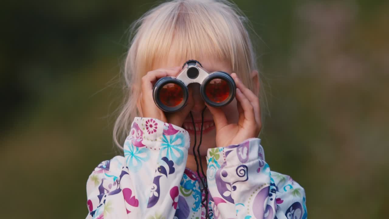 쾌활한 아이가 쌍안경을 통해 본다