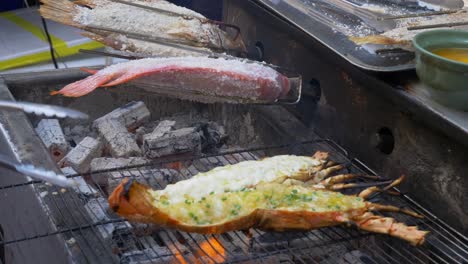 Puesto-De-Restaurante-De-La-Calle-Tailandia-Langosta-A-La-Parrilla-Sobre-Carbón-Cocinar-Tilapia-Sobre-Fuego-De-Carbón