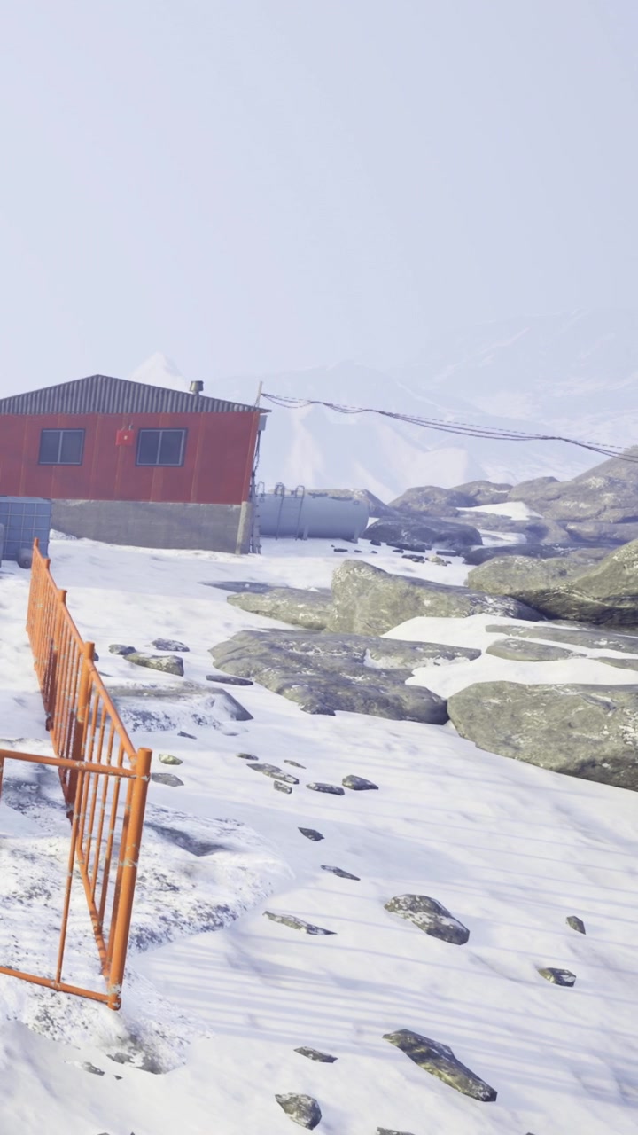 Cabaña en la nieve con rocas y montañas a lo lejos durante el invierno.