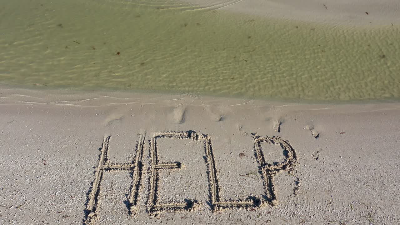 모래에 쓰여진 도움의 정적 샷