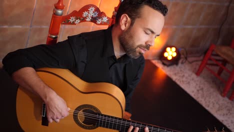hombre barbudo tocando la canción en la guitarra