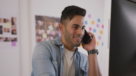 Mixed-race-man-phoning-in-creative-office