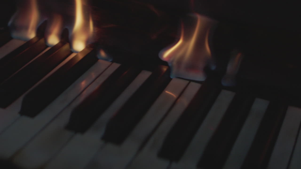 Piano keys melt as flames rise from underneath