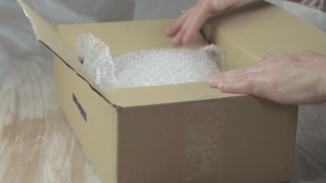 Empacar-Una-Caja-Con-Plástico-De-Burbujas