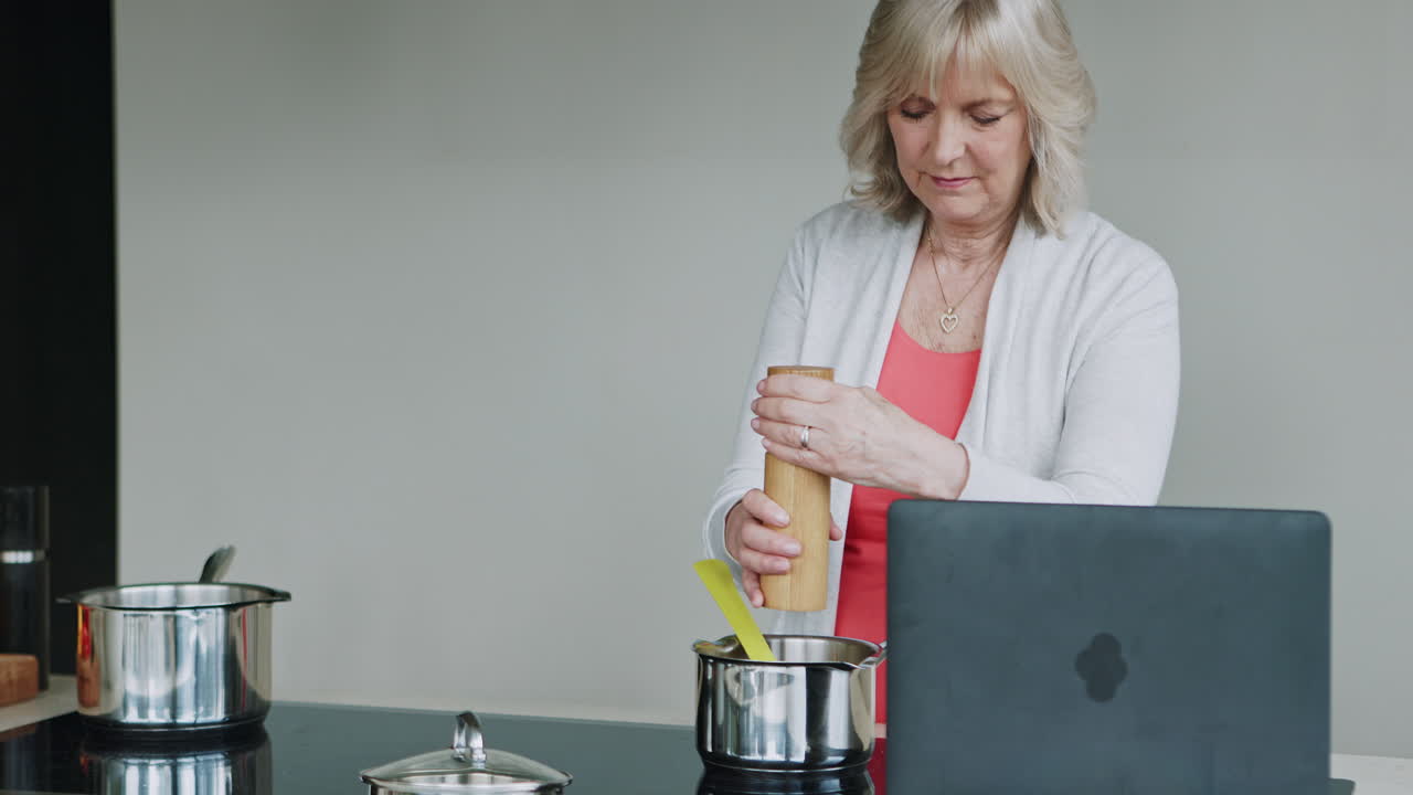 Senior woman cooking a recipe in her kitchen